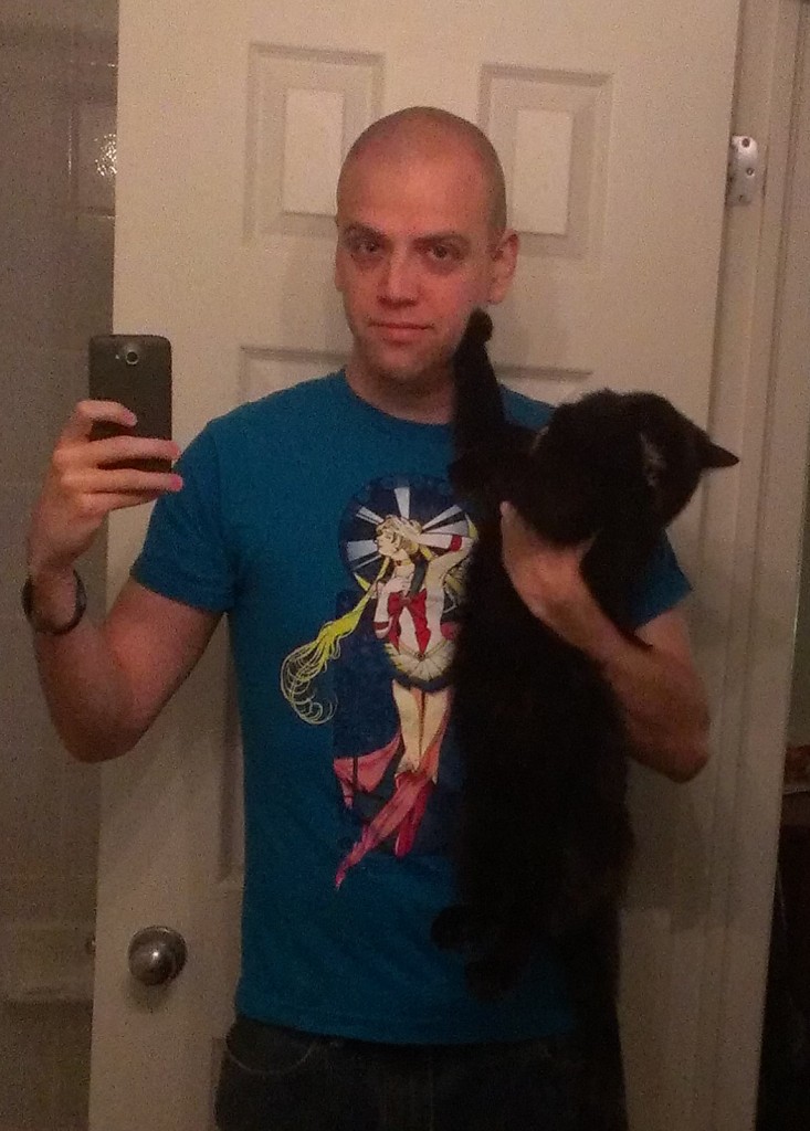 Adam wearing "By Moonlight" shirt with Luna the cat