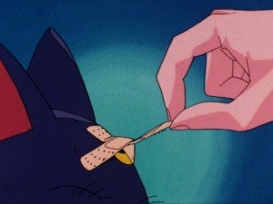 Sailor Moon episode 1 - Usagi removing a bandage from Luna's head