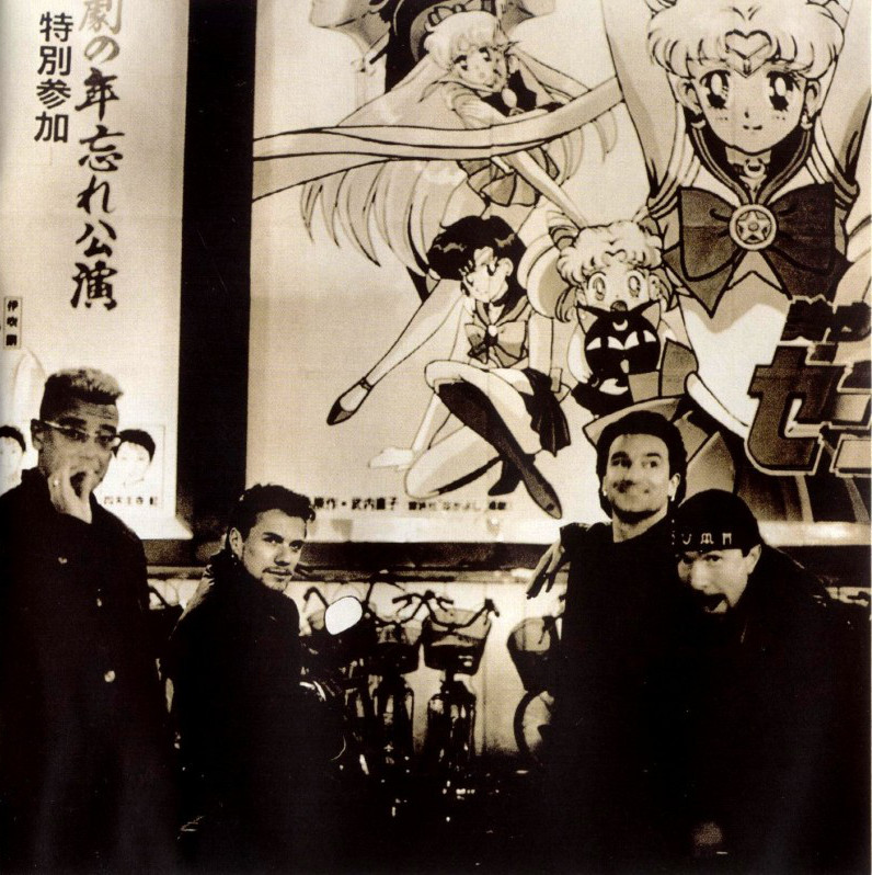 U2 in front of a Sailor Moon R The Movie poster